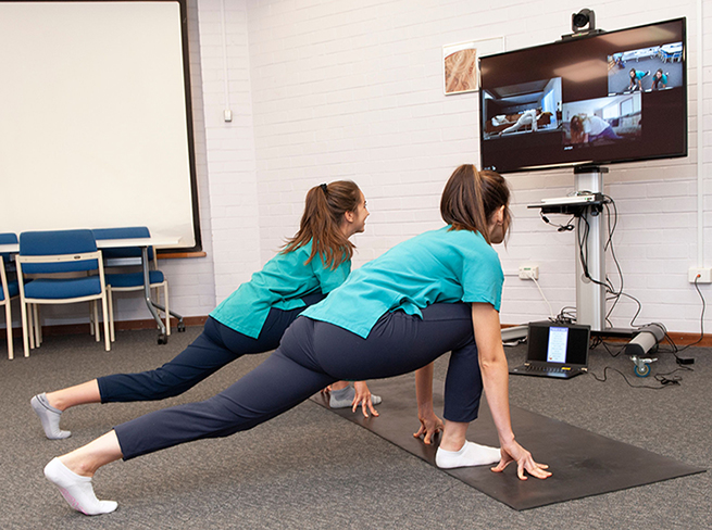 Two female physiotherapists exercising with patients over telehealth