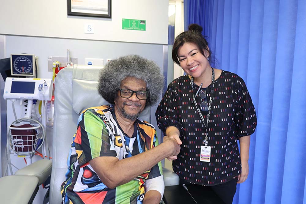 Patient, Paul, shaking hands with an individual from his medical care team.